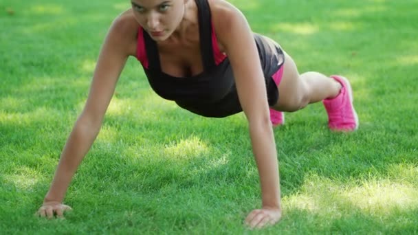 Fitness mujer entrenamiento flexiones ejercicio sobre hierba en el parque de verano — Vídeos de Stock