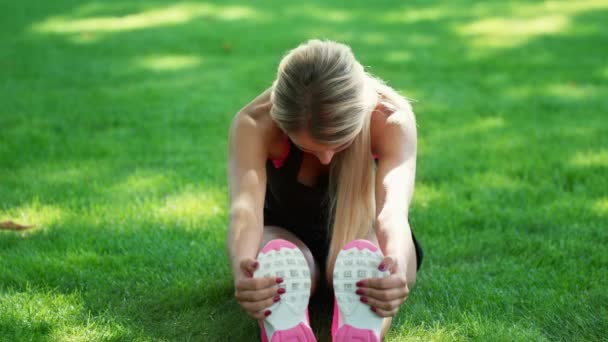 Sportovní ženu, která cvičí protahovací cvičení v letním parku. Fitness žena pro zahřátí — Stock video