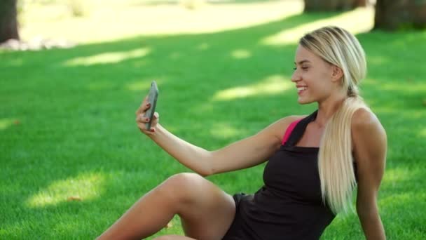 Donna sportiva scattare foto selfie sul telefono cellulare nel parco estivo — Video Stock