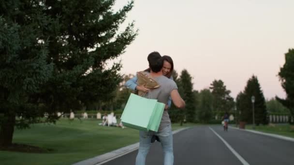 Couple in love having fun in summer park after successful shopping — Stock Video