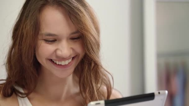 행복 한 여자 얼굴 보고 태블릿 컴퓨터입니다. 타블렛과 웃는 여자 — 비디오