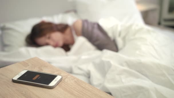 ケータイのアラームは、ベッドで女性によって覚ます。朝に目を覚ます。女性の新しい日 — ストック動画