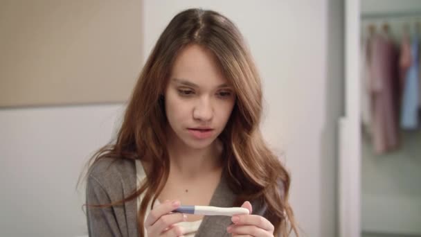 Mujer preocupada esperando los resultados de la prueba de embarazo. Chica mirando la prueba de embarazo — Vídeos de Stock