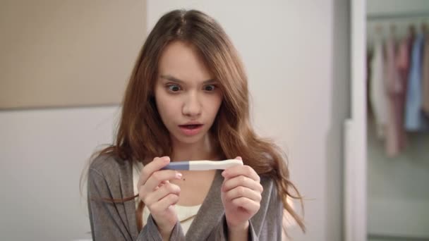 Chockad kvinna positivt graviditetstest resultatet. Porträtt av gravid kvinna test — Stockvideo