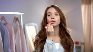 Evde sıvı ruj uygulayan genç bir kadın. Sabah güzel kız makyaj