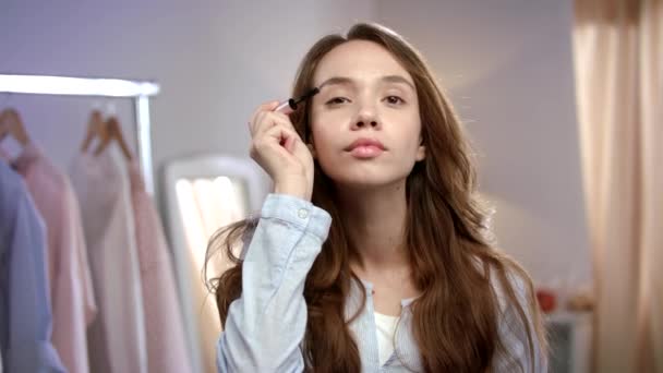 Młoda kobieta stosujące tusz do rzęs. Uroda kobieta stosujące makijaż na rano — Wideo stockowe