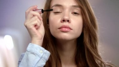 Kadın Kirpiklere Maskara uyguluyor. Kız uygulama güzellik makyaj