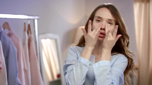Junge Frau Gesicht Hautpflege. Nahaufnahme eines hübschen Mädchens, das Gesicht mit Lotion berührt — Stockvideo
