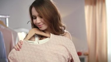 Genç kadın gardırop giysiler seçmek. Yeni kıyafetlere neşeli kadın