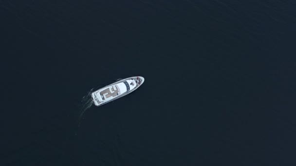 Yate de lujo navegando aguas profundas. Vista aérea del barco blanco girando — Vídeo de stock