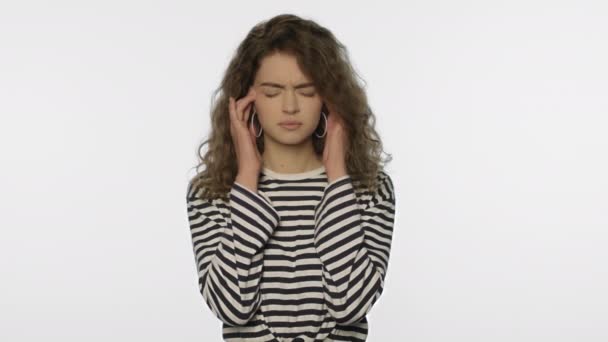 Müde Frau Kopfschmerzen auf weißem Hintergrund. Porträt einer aufgebrachten Frau, die den Kopf berührt — Stockvideo