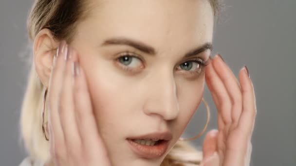 Junge Frau berührt Gesichtshaut in Zeitlupe. Frau tut Gesichtsmassage — Stockvideo