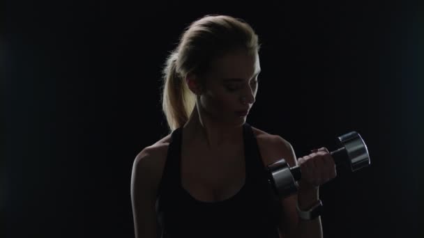 Sport woman exercising with dumbbells in studio. Silhouette of fitness woman — Stock Video