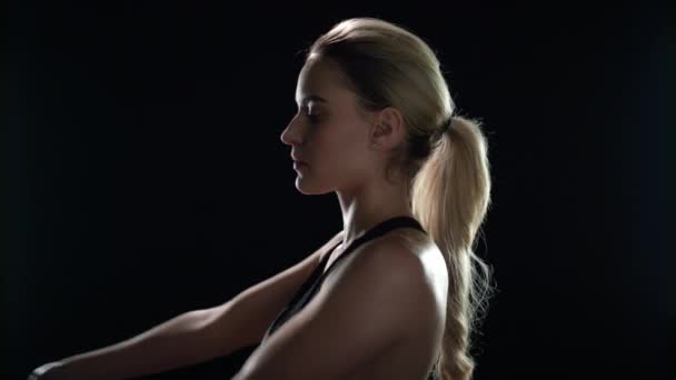 Sport vrouw doet stretch oefening op zwarte achtergrond. Fit meisje opwarmen — Stockvideo