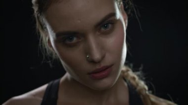 Siyah arka planda spor kadın portresi. Terli kadın yüzünü kapat.