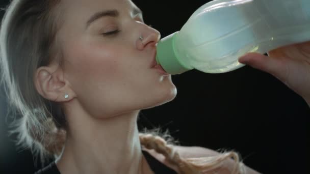 Sport vrouw drinken water uit fitness fles op zwarte achtergrond — Stockvideo