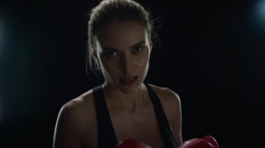 Spor kadın, kardiyo eğitiminde kırmızı boks eldivenleriyle yumruk atıyor. Kadın boksör