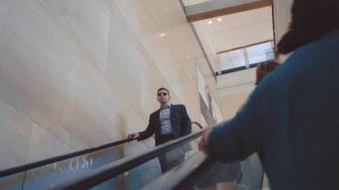 Şık takım elbise ve güneş gözlüğü tırmanıcı aşağı gidiyor Modern adam