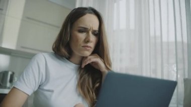 Yorgun kadın dizüstü bilgisayara bakıyor. Dizüstü bilgisayar kullanan üzgün kadın portresi
