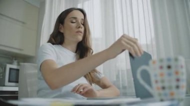 Stresli kadın ev işyerinde dizüstü bilgisayar kapanış ve çay fincan içme