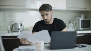 Evde belgelerle çalışan düşünceli adam. İş adamı evrak işi yapıyor