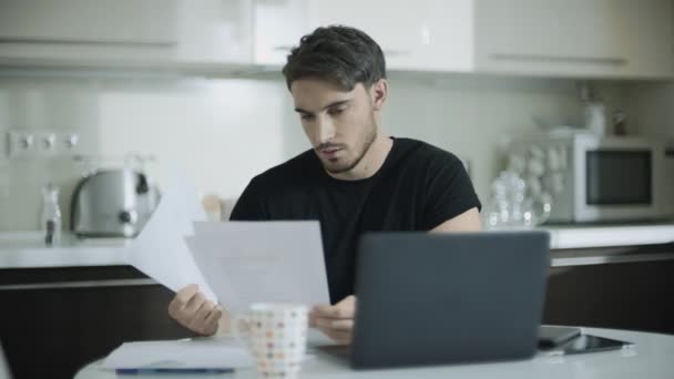 Worried business man looking papers at home workspace. Portrait of upset man — Stockvideo