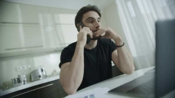Usmívající se muž mluvící mobilním telefonem na domácím pracovišti. Šťastný podnikatel volá telefon — Stock video