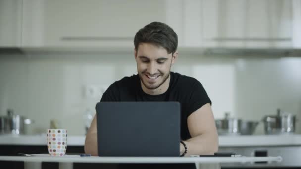 Деловой человек работает ноутбук компьютер и пить чай на домашней кухне — стоковое видео