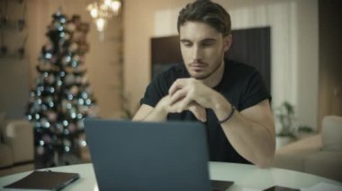 Yılbaşı evinde dizüstü bilgisayarda çalışan bir programcı. Erkek serbest çalışan.
