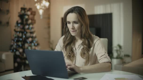 Молода жінка купує онлайн в різдвяний час. Різдвяні онлайн покупки — стокове відео