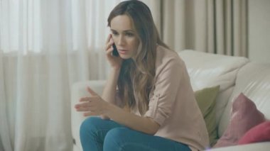 Kızgın kadın evde telefon konuşuyor. Üzgün kişi arama cep telefonu portresi