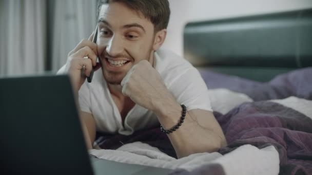 Un hombre feliz hablando por teléfono en el sofá de casa. Estilo de vida de las telecomunicaciones — Vídeos de Stock