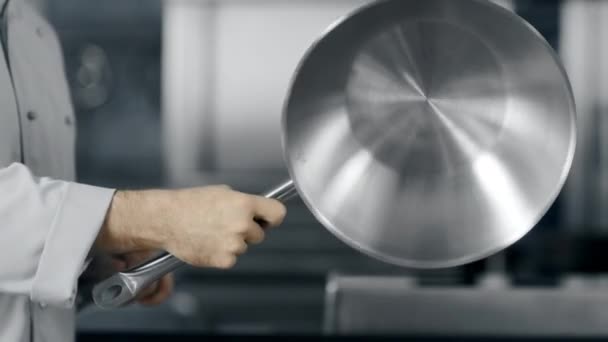 Chef hands rotating wok at kitchen. Closeup man hands playing with wok. — Stock Video