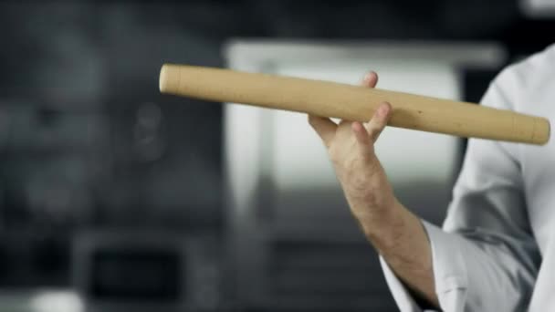 Chef speelt met roller op de werkplek. Close-up man handen twist roller in de keuken — Stockvideo