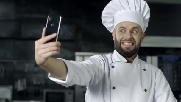 Professionele chef-kok poseren in de keuken. Chef-kok maken selfie foto met mobiele telefoon — Stockvideo