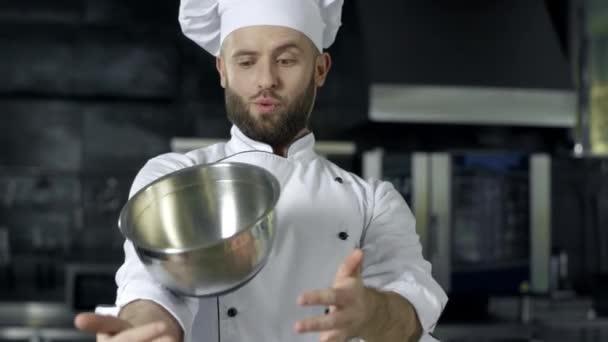 Koch spielt mit Schüssel. Koch-Mann bereitet sich in professioneller Küche auf das Kochen vor. — Stockvideo