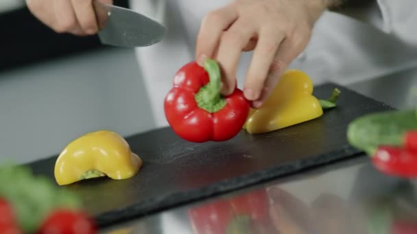 Koch kocht Essen in Küche Restaurant. Großaufnahme Koch Hände schneiden Paprika. — Stockvideo