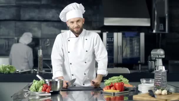 Chef man making fun at kitchen restaurant. Smiley male chef posing with knives. — Stock Video