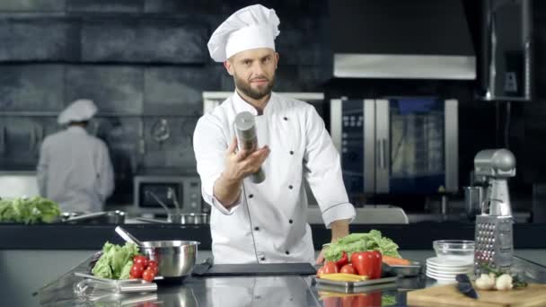 Chef profesional que se prepara para cocinar en la cocina. Chef calentando con pepperbox — Vídeo de stock