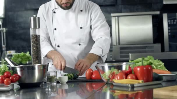 Szef kuchni gotowania świeżych sałatek w kuchni. Zbliżenie mężczyzna ręce cięcie ogórek. — Wideo stockowe