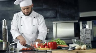 Restoran mutfağında aşçı yemek yapıyor. Taze salata yapan profesyonel şef.