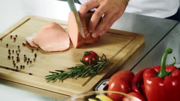 シェフはナイフで肉を切る手。シェフの手はスローモーションでハムをスライス. — ストック動画