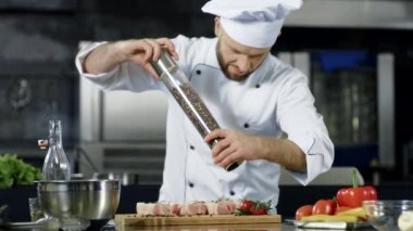 Erkek şef mutfakta et içiyor. Closeup şef işyerinde biftek biber