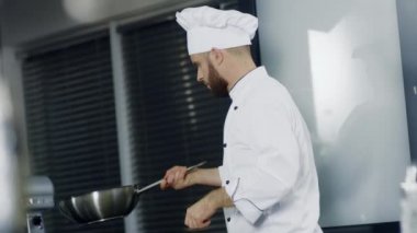 Mutfak restoranında wok'ta yemek pişiren şef. Man şef tavada asya yemekleri hazırlar