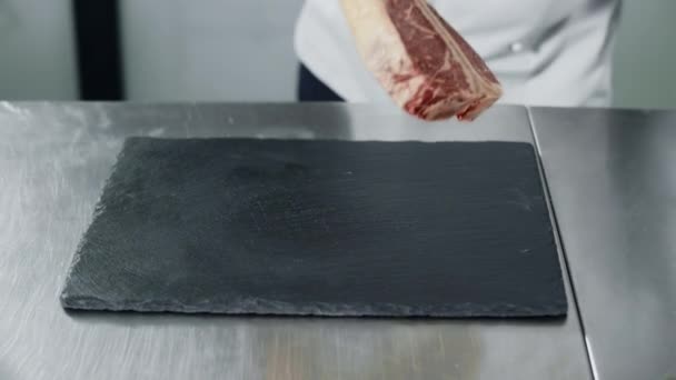 Chef bereidt zich voor op koken in restaurant Kitchen. Close-up chef-kok handen met rauwe steak. — Stockvideo