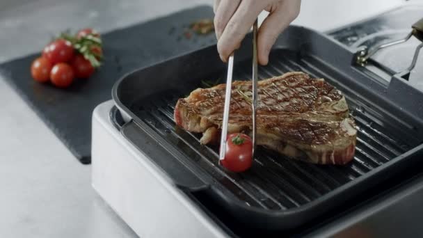 Chef cooking grill steakn. Closeup chef hands putting vegetables at frying fork — Stock Video