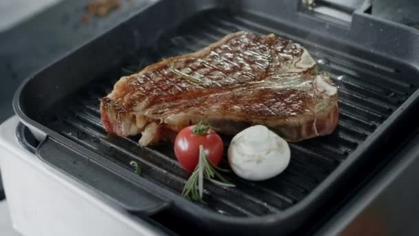 Färsk stek stek på PANNKAKSLAGG stekpanna. Närbild nötkött med grönsaker matlagning på grill — Stockvideo