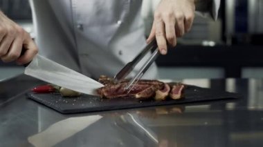 Şef mutfak restoranında biftek kesiyor. Closeup şef dilimleme et