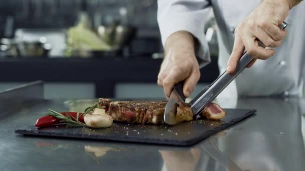 Şef mutfakta ızgara biftek kesme eller. Closeup şef eller kızarmış et dilimleme — Stok video