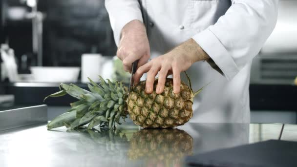 Chef hugga ananas i slow motion. Man skära färsk frukt. — Stockvideo